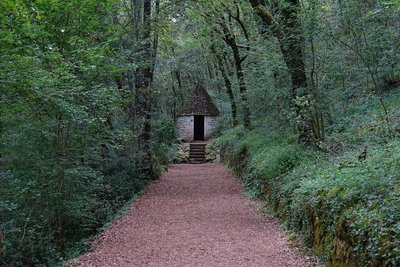 Les Jardins De Marqueyssac — Woodland path leading to a small stone shelter